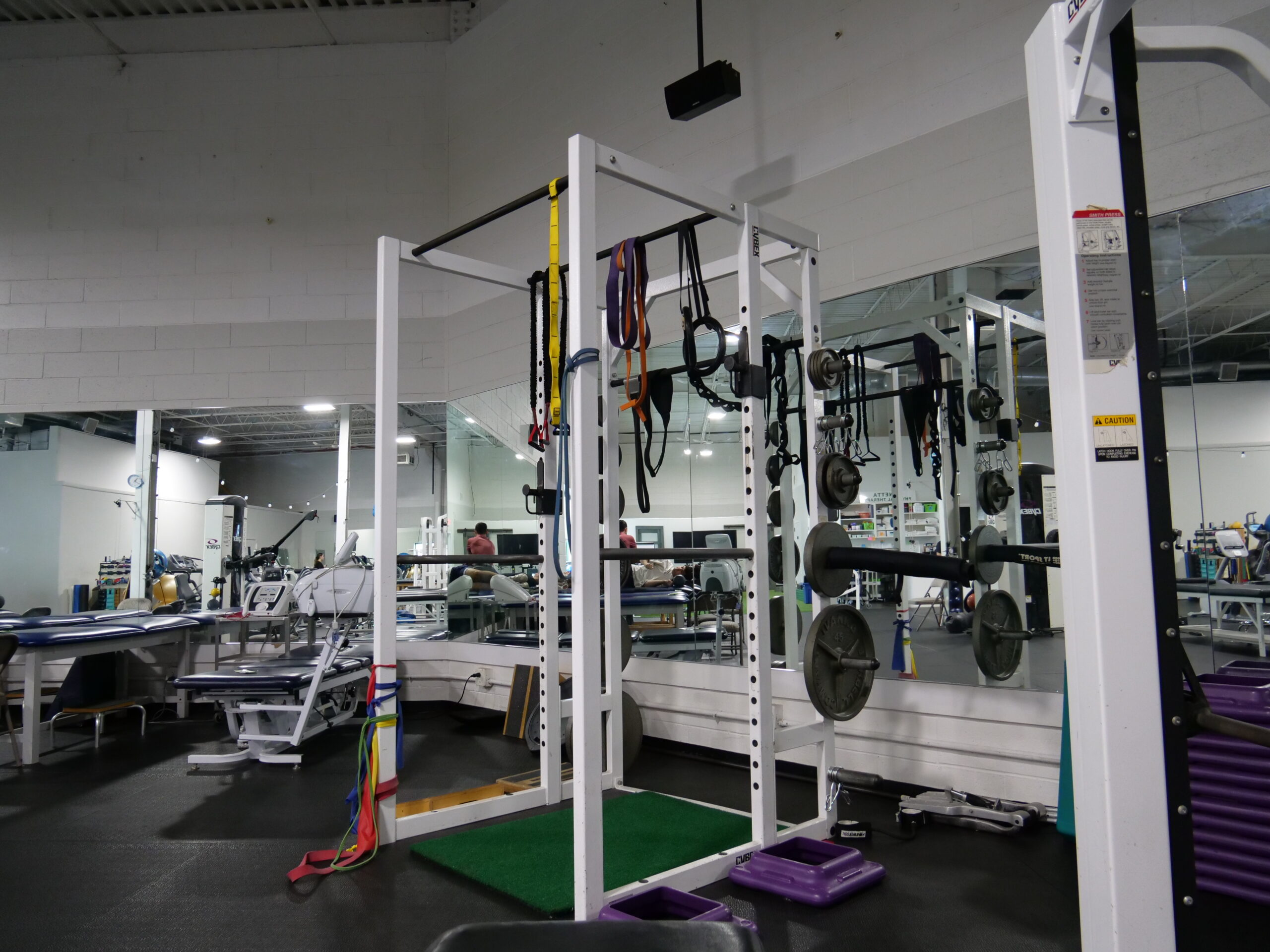 Strength training area with squat rack and equipment at Panetta Physical Therapy